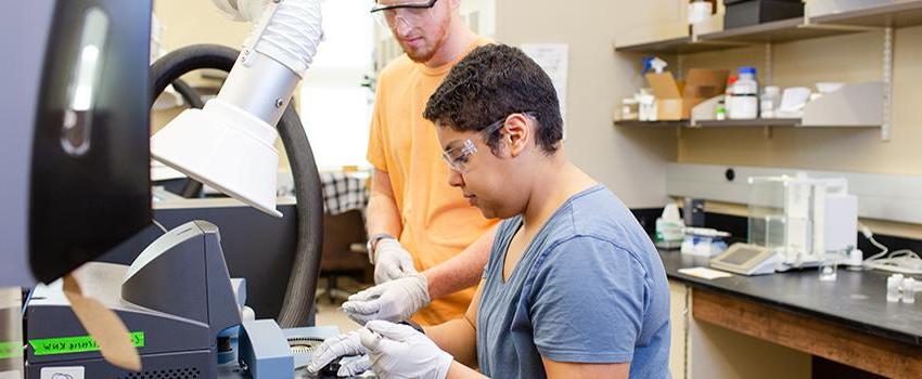 Two students working on a slide in the lab.