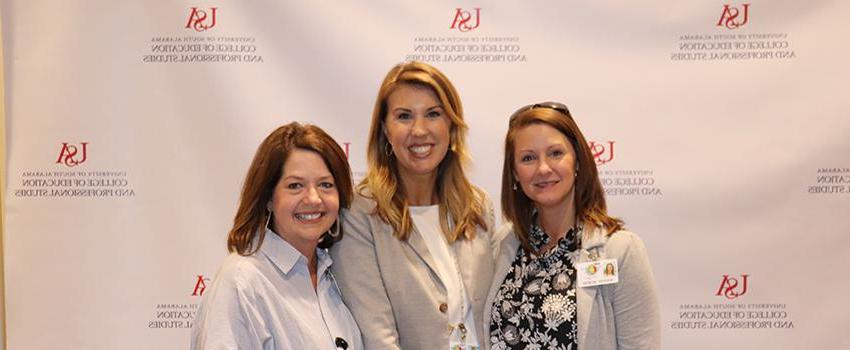 Three female instructors in front of USA backdrop