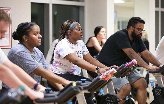 People on bikes in spin class.