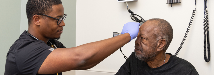 Physician examines a senior, male patient.