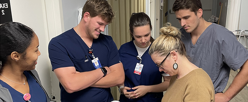 Medical, pharmacy, and nursing students are debriefing with the preceptor to discuss an treatment plan for the patient. 