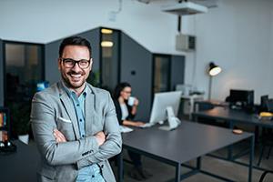 Man smiling in front woman working on computer at table.