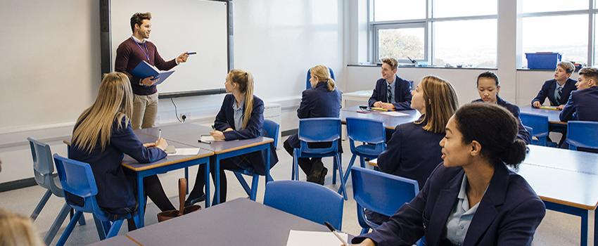 Teacher in front of class teaching to class.