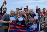 A group of students holding the Jags flag abroad.