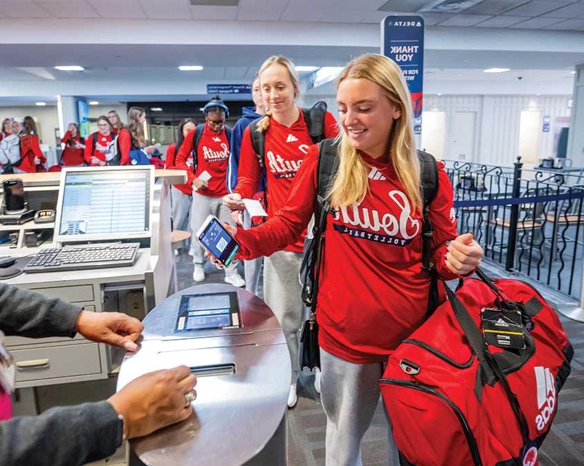 Volleyball team going through line to get on plane.