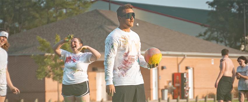 Students playing dodgeball on campus at a tournament.