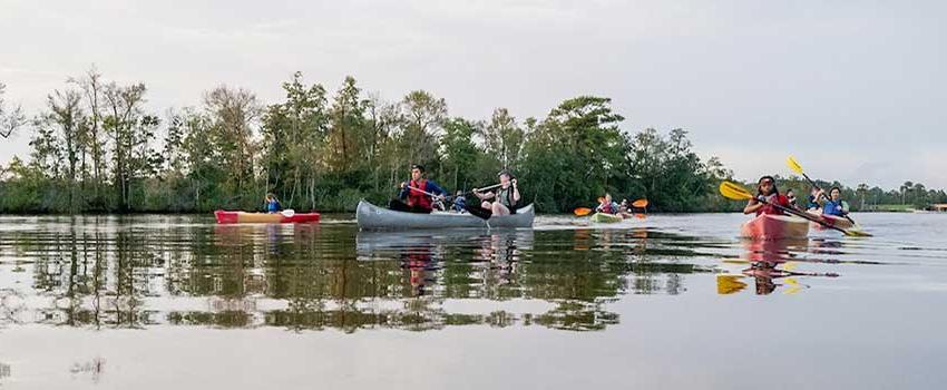 Students paddling in canoes.