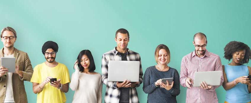 A group of people holding laptops, notebooks, and phone.