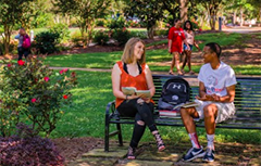 Students sitting outside on bench