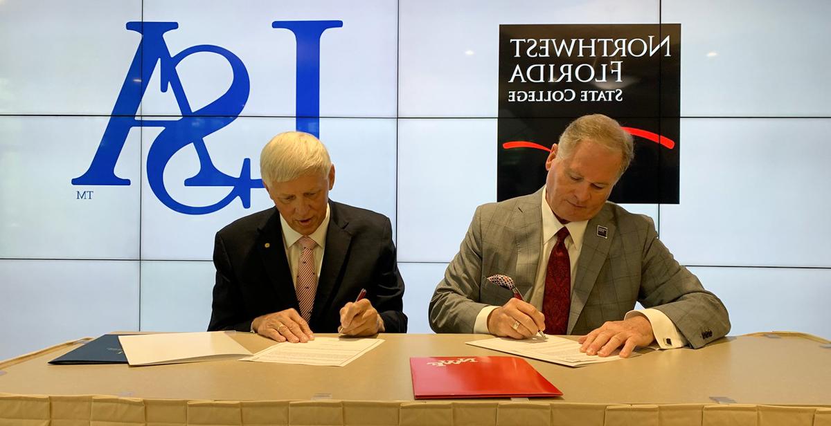  Dr. Devin Stephenson, left, Northwest Florida State College president, and Dr. Tony Waldrop, University of South Alabama president, sign an agreement that adds NWF State College to the list of Gulf Coast institutions that have joined South's Pathway USA program, increasing access to a four-year education for community college students. 