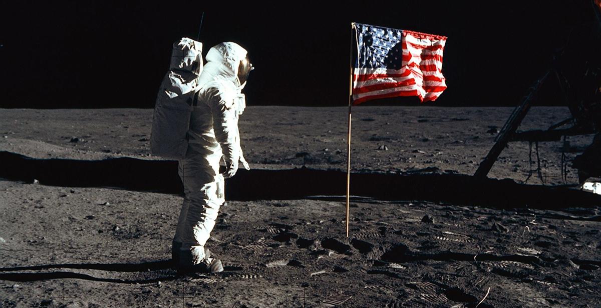 Astronaut Edwin "Buzz" E. Aldrin Jr., lunar module pilot of the first lunar landing mission, poses for a photograph beside the deployed United States flag. NASA photo.  