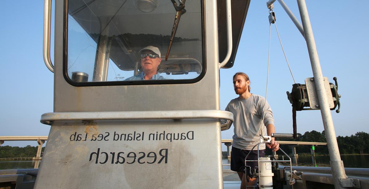 Dr. John Lehrter, associate professor of marine science, pilots a boat through Mobile Bay, where he and graduate Chris Mikolaitis took water samples to measure the health of its marine ecosystem. 