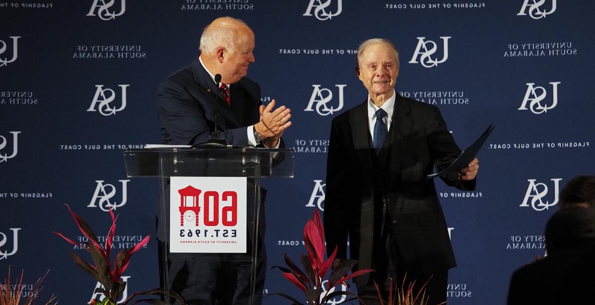 University of South Alabama President Jo Bonner, right, announces a $20 million gift from Abraham "Abe" Mitchell at the University's 60th Anniversary celebration. The donation will be used to build a new performing arts center on campus.  