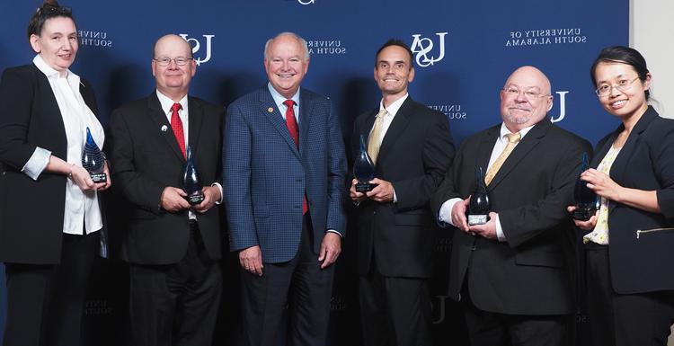 2nd annual USA Technology and Research Showcase honorees. Dr. Na Gong, professor of electrical and computer engineering; Dr. James Davis, professor of chemistry; Dr. Jordan Shropshire, professor of information systems and technology; USA President Jo Bonner; Dr. Sean Powers, professor of marine and environmental sciences and senior marine scientists at the Dauphin Island Sea Lab; Dr. Marie Migaud, professor of pharmacology and oncology.