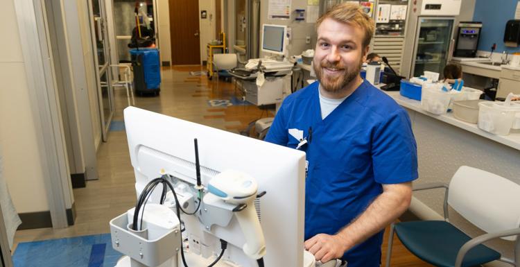 Luke Thomas, a University of South Alabama graduate, at his job at USA Health University Hospital 