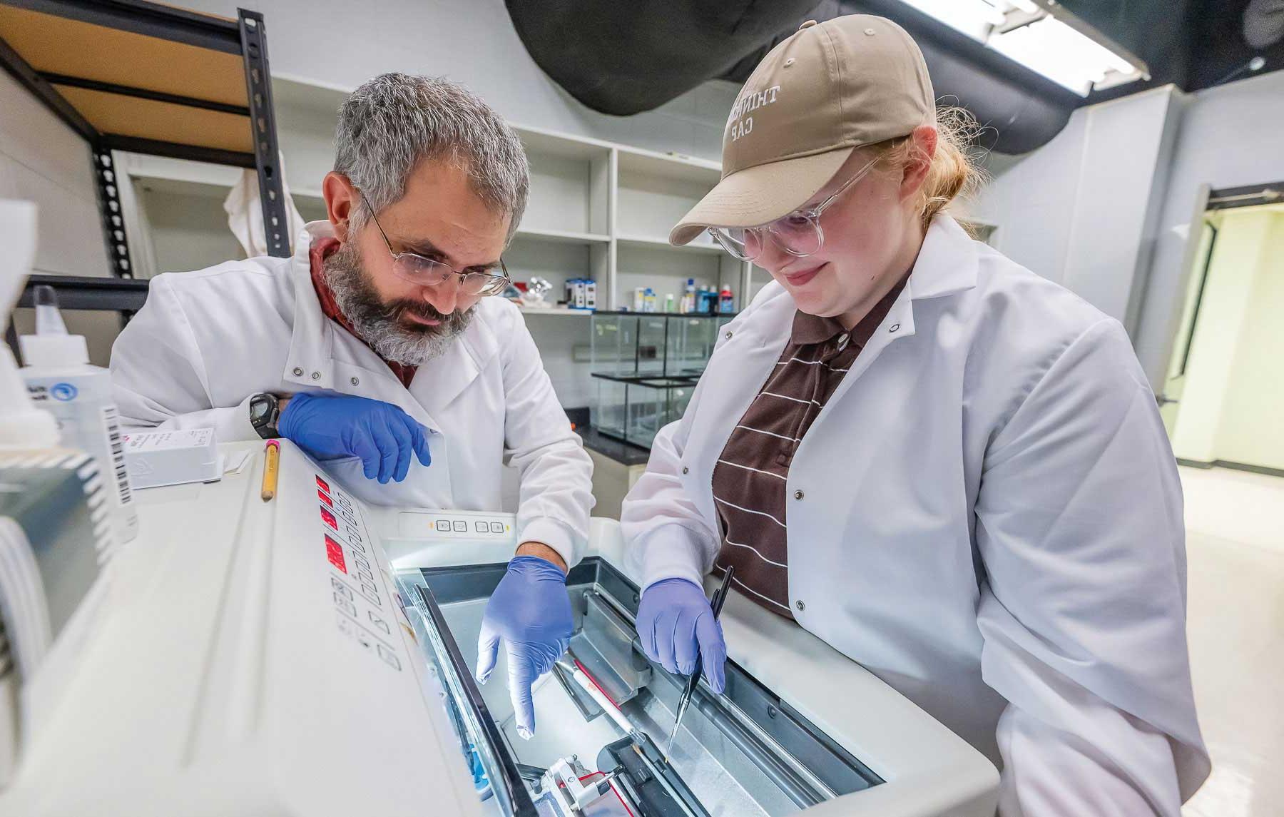 Dr. Jonathan Pérez, right, an assistant professor of biology at South, in his Bird Brain’d lab at a cryostat machine, which preserves tissue samples by deep-freezing and allows them to be studied in their cryogenically frozen state. The machine was funded through a National Science Foundation grant he was awarded last year. 