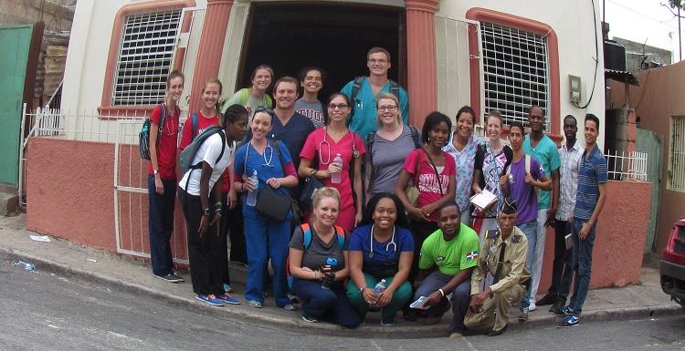 USA nursing students, Foundation for Peace staff and others gather outside a church used as a clinic site in the community of Los Mina.