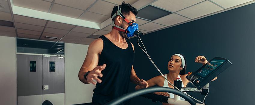 Man running on treadmill with breathing machine on.