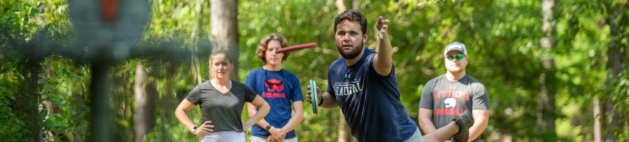 Students playing disc golf on campus.