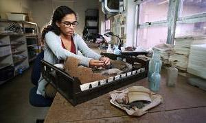 Student working in lab with artifact.