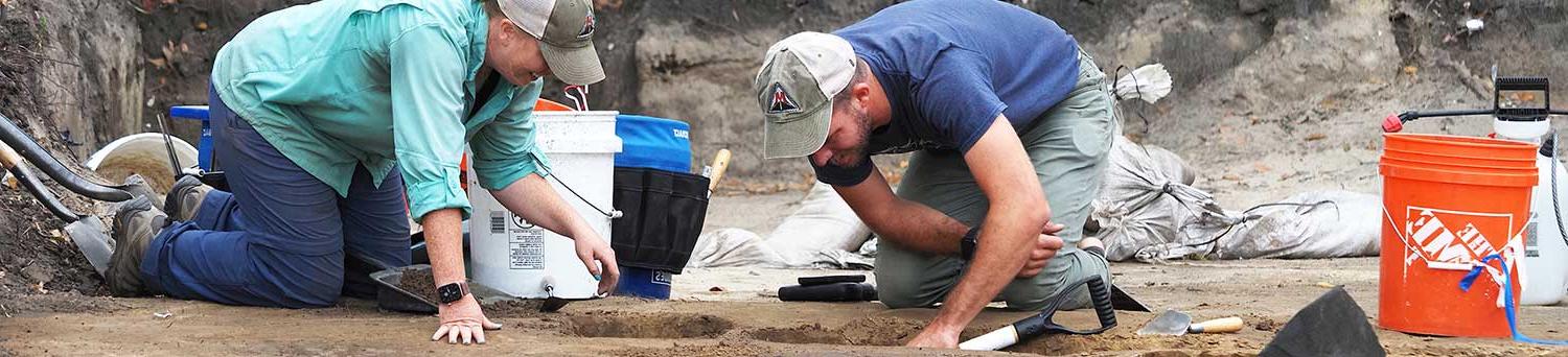 Emily Warner, right, with the USA Center for Archaeological Studies, and Thomas Grace, with Wiregrass Archaeological Consulting, bisect a feature in the soil at a site that is along the route for a proposed Mobile Bay bridge.